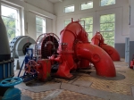 Große rote Pumpe in einem hellen Raum mit großen Fenstern und blauer Maschine im Hintergrund